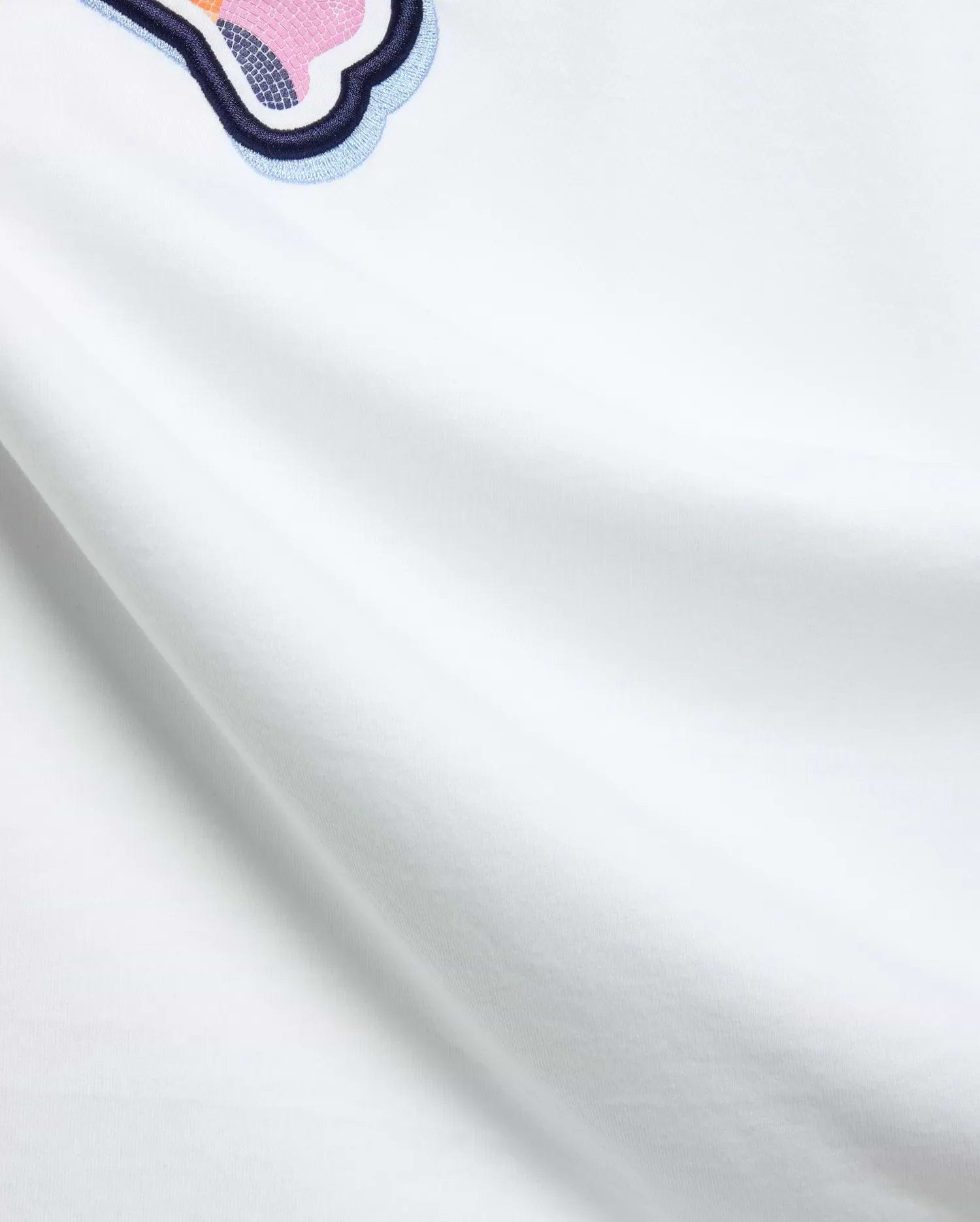 White Mens Ethan Graphic Tee, classic fit jersey, featuring a large embroidered Psycho Bunny skull logo with dark blue, light blue, pink, and orange mosaic details. (6)
