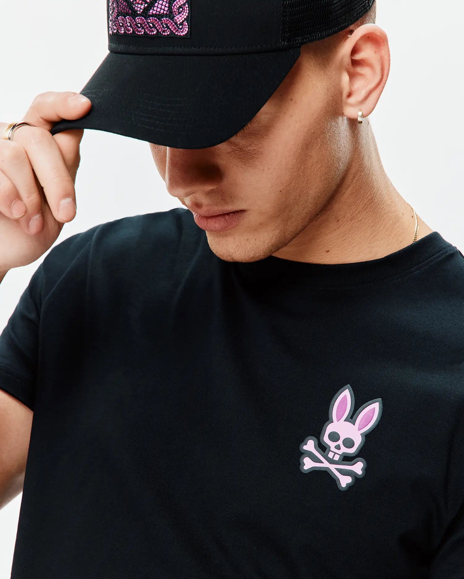 Mens Frank Back Graphic Tee, a black jersey knit t-shirt with a small pink and grey Psycho Bunny skull logo on the left chest, offering a classic fit.