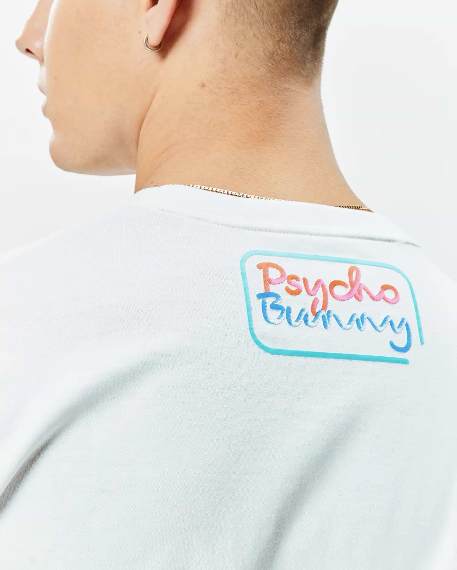 White Mens Dayton Graphic Tee in soft jersey knit, featuring a large, vibrant Psycho Bunny text graphic on the upper back, outlined in light blue. (3)