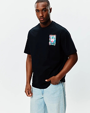 Mens Isaac Relaxed Fit Tee, black jersey with a small chest graphic of the Psycho Bunny skull logo in vibrant pink, blue, green watercolor splatter.