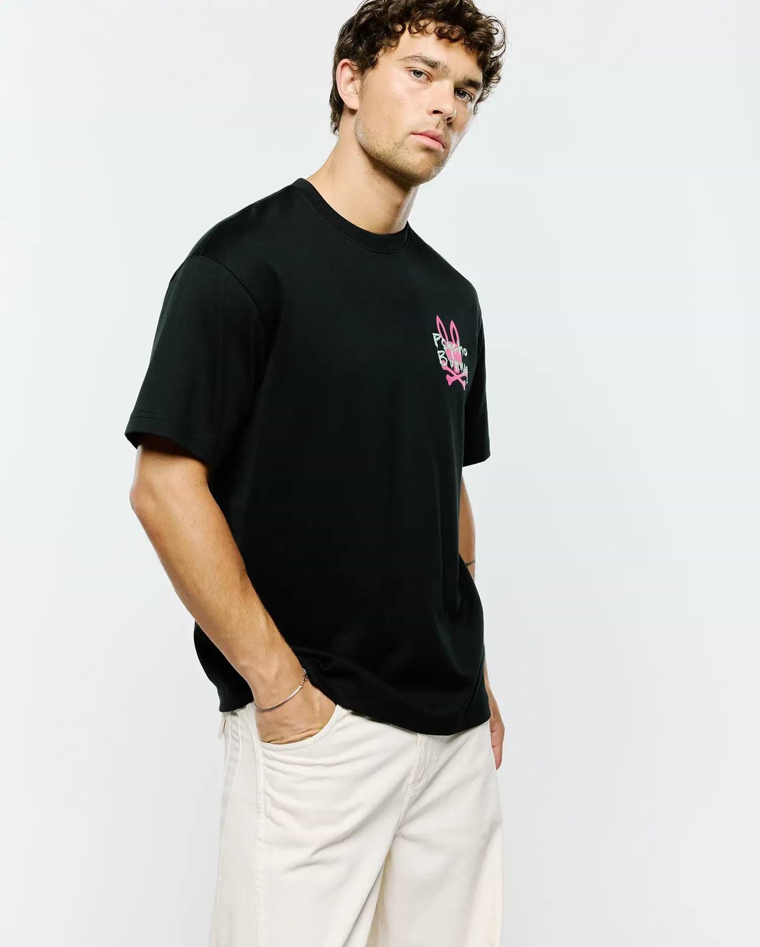 Mens Duncan Relaxed Fit Tee, black jersey knit with a relaxed fit, featuring a prominent pink and white Psycho Bunny skull and crossbones logo on the left chest.