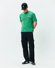 Mens Duncan Relaxed Fit Tee. Vibrant green jersey t-shirt with a relaxed fit, featuring a white embroidered Psycho Bunny skull logo and text on the left chest.