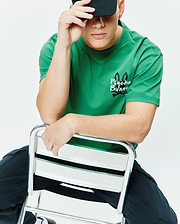 Mens Duncan Relaxed Fit Tee in vibrant green jersey, featuring a relaxed fit and the iconic black and white Psycho Bunny skull logo with text and crossbones on the left chest.