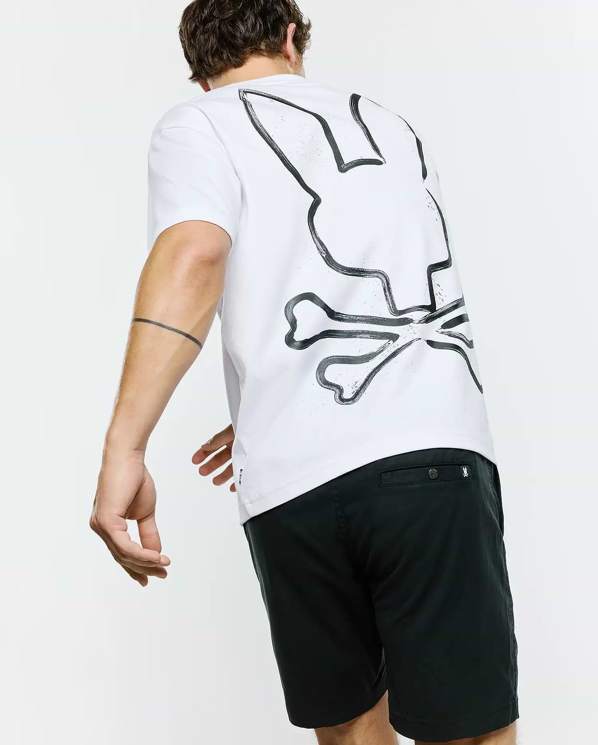 White Mens Duncan Wordmark Relaxed Fit Tee in soft jersey fabric, featuring a large, distressed black Psycho Bunny skull logo graphic prominently displayed on the back.