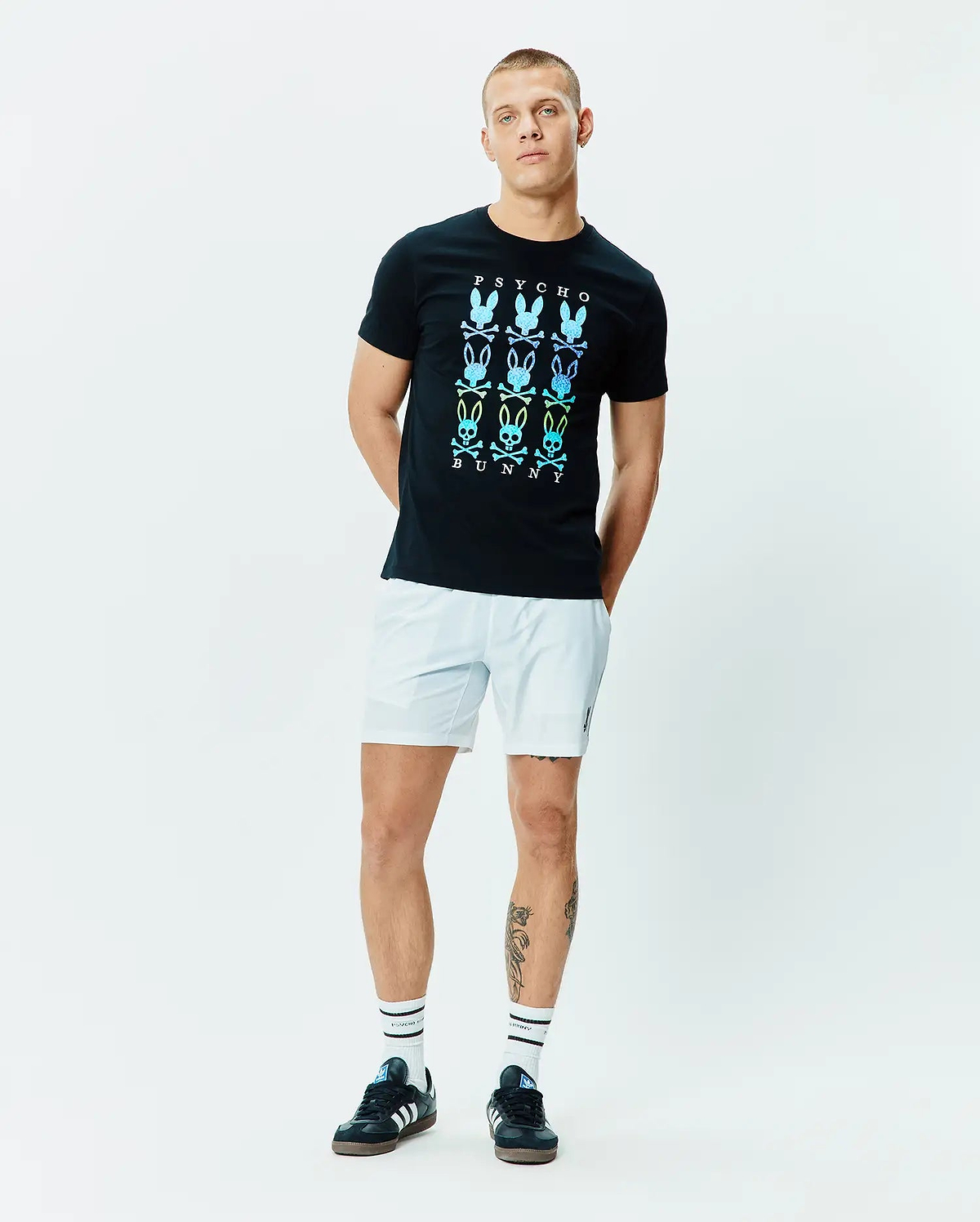 Mens Colt Graphic Tee, black, classic fit, smooth jersey knit, featuring a large central chest graphic of nine gradient blue, green, yellow Psycho Bunny skull logos with PSYCHO and BUNNY text. (5)