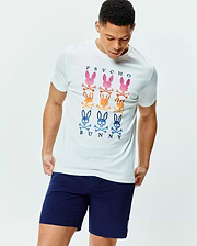 Mens Colt Graphic Tee. White classic fit jersey t-shirt with a large chest graphic featuring nine colorful Psycho Bunny skull and crossbones logos in pink, orange, and blue, with navy PSYCHO BUNNY text. (2)
