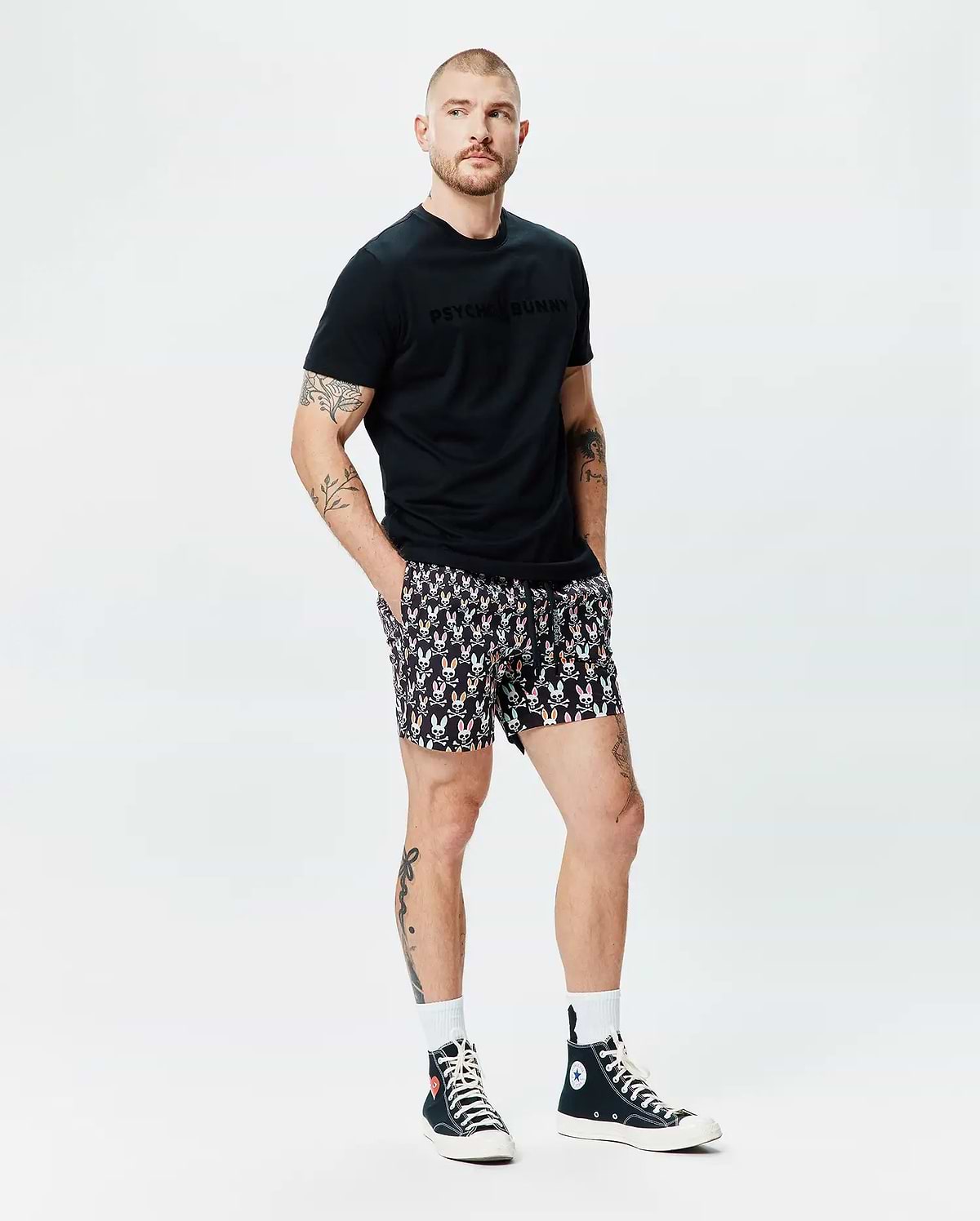 Black Mens Royce Graphic Tee, classic fit, soft jersey, featuring a tonal Psycho Bunny chest graphic, paired with black relaxed-fit shorts showcasing an all-over vibrant bunny skull and crossbones print. (4)