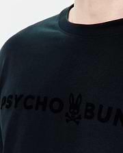 Mens Royce Graphic Tee, a classic fit black jersey t-shirt with a large, tonal velvety Psycho Bunny text and iconic bunny skull logo graphic on the chest. (3)