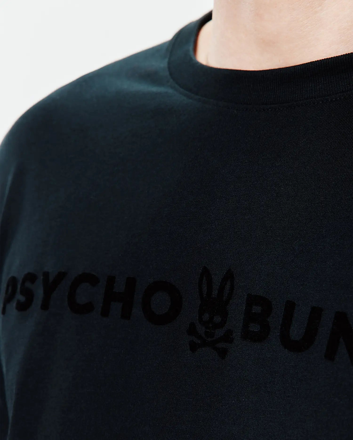 Mens Royce Graphic Tee, a classic fit black jersey t-shirt with a large, tonal velvety Psycho Bunny text and iconic bunny skull logo graphic on the chest. (3)