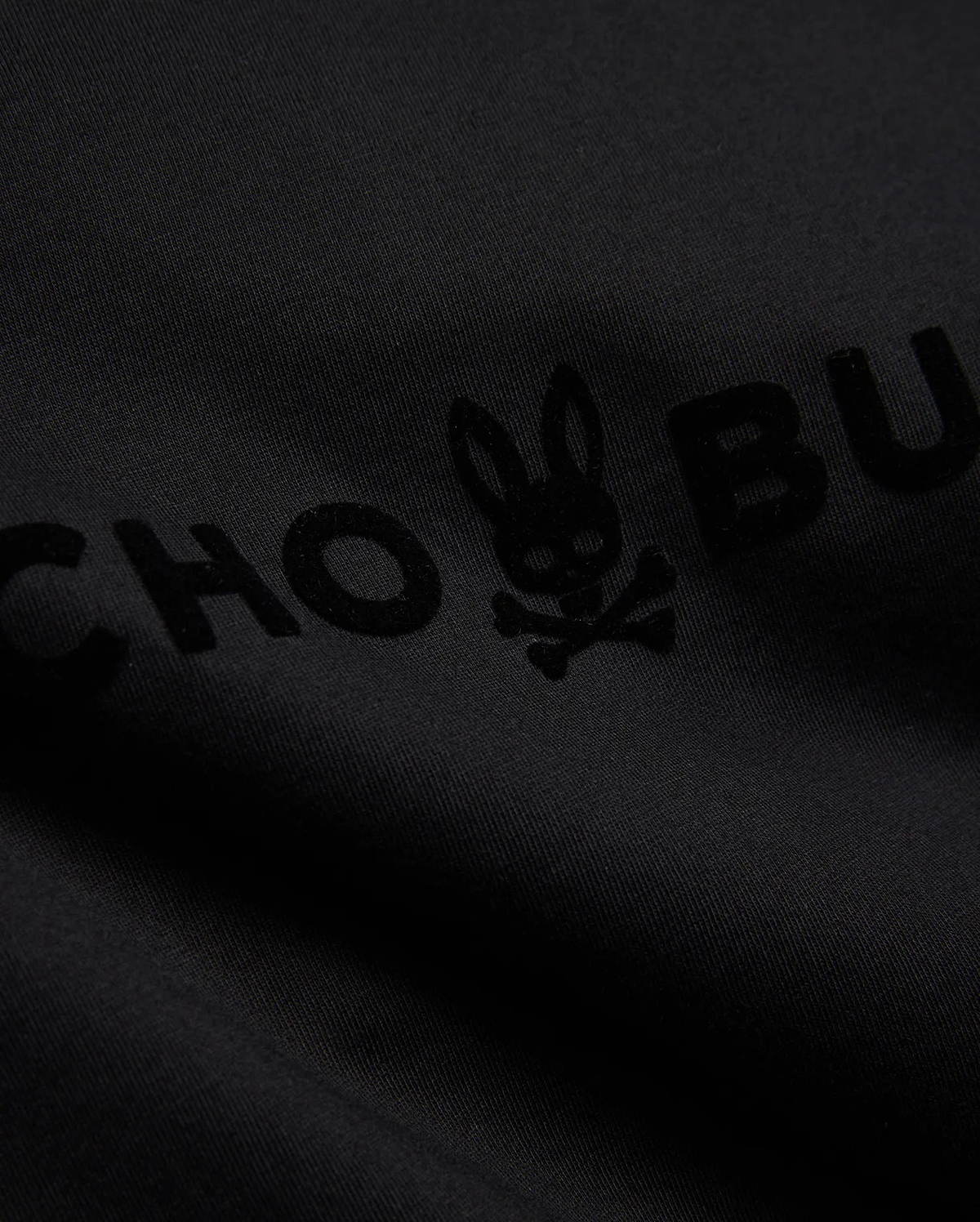 Mens Royce Graphic Tee, a black jersey knit t-shirt with a large, subtly raised, tonal black flocked Psycho Bunny skull logo and brand name graphic. (6)