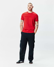 Mens Royce Graphic Tee, a vibrant red classic fit jersey t-shirt featuring a prominent, tonal embossed Psycho Bunny logo text centered on the chest.