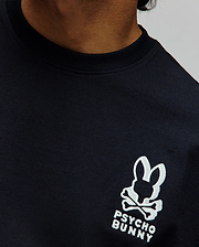 Mens Toby Oversized Tee in dark navy jersey knit, featuring a prominent embroidered white Psycho Bunny skull logo with crossed bones and text on the left chest. (2)