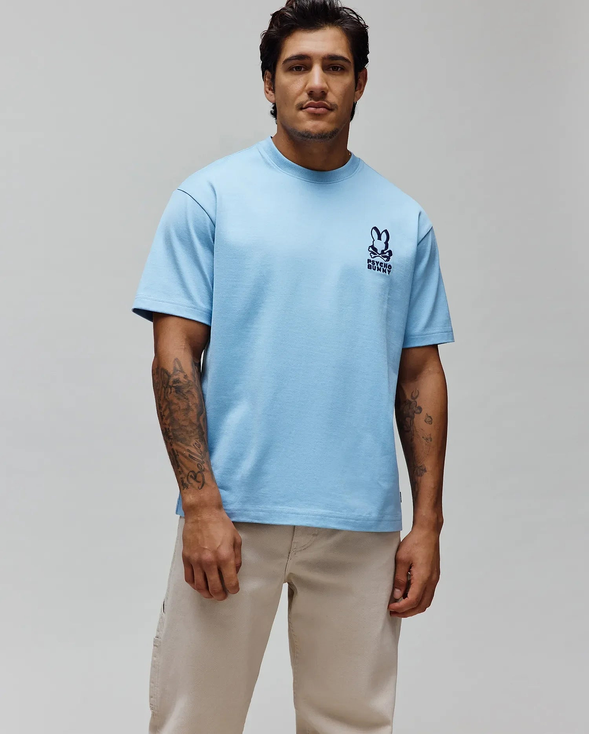 Mens Toby Oversized Tee in light blue, crafted from soft jersey fabric, featuring an iconic small, embroidered navy Psycho Bunny skull and crossbones logo with text on the left chest, embodying refined streetwear. (3)