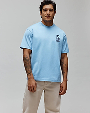 Mens Toby Oversized Tee in light blue, crafted from soft jersey fabric, featuring an iconic small, embroidered navy Psycho Bunny skull and crossbones logo with text on the left chest, embodying refined streetwear. (3)