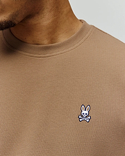 Mens Maxton Waffle Tee in tan, featuring a classic fit and textured waffle knit fabric. A small, embroidered Psycho Bunny skull logo in white, blue, and black adorns the left chest.
