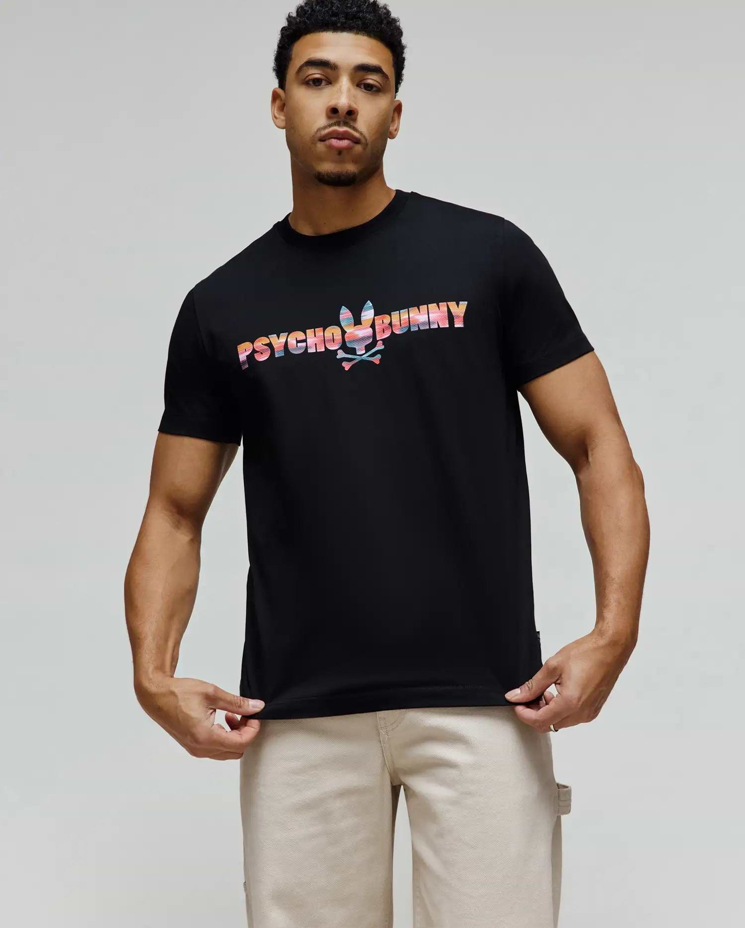 Mens Raphael Wordmark Tee, black classic fit jersey t-shirt featuring a large, vibrant multicolor Psycho Bunny wordmark with an integrated bunny skull graphic on the chest. (1)