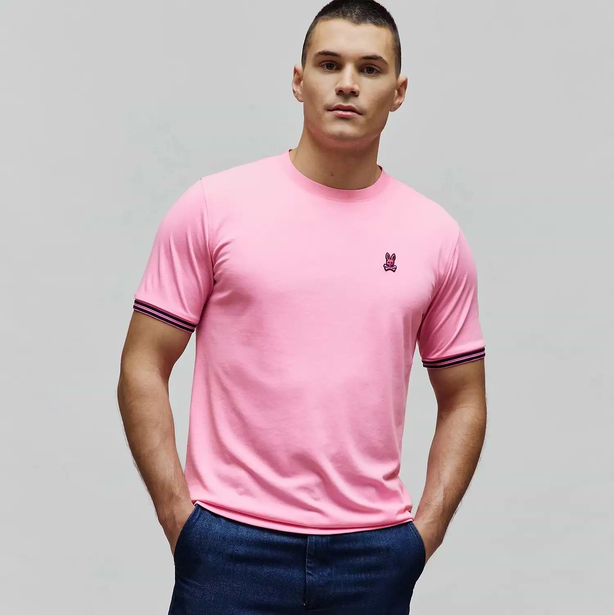 Mens Clark Performance Tee in bright pink, featuring a classic fit, smooth jersey knit, small fuchsia embroidered Psycho Bunny skull logo on the left chest, and navy and pink striped sleeve cuffs. (3)