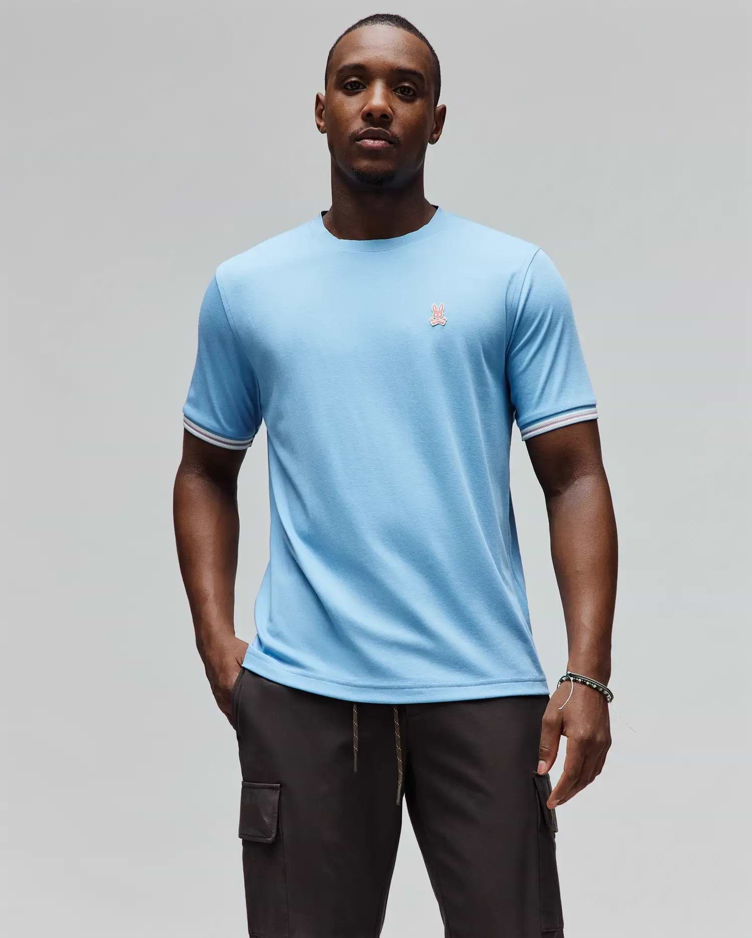 Mens Clark Performance Tee, a sky blue classic fit jersey knit t-shirt featuring a small embroidered pink Psycho Bunny skull logo on the left chest and white and red striped ribbed sleeve cuffs. (1)