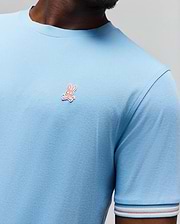 Mens Clark Performance Tee, a light blue classic fit jersey knit t-shirt with a small embroidered pink Psycho Bunny skull logo on the left chest and a striped sleeve cuff. (2)