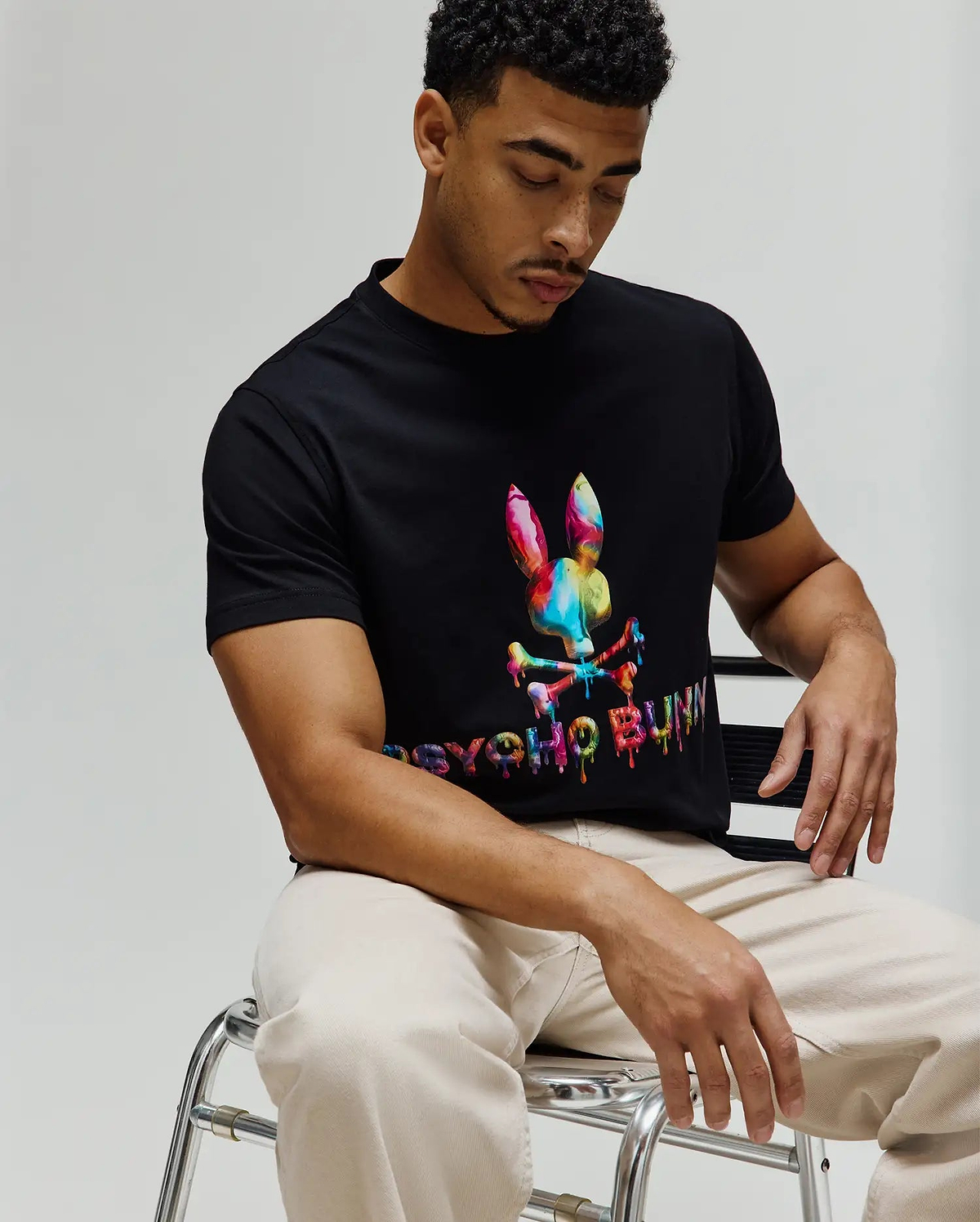 Mens Wells Graphic Tee, a black classic fit jersey t-shirt featuring a large, vibrant multicolor drip-effect Psycho Bunny skull logo and matching text on the center chest. (3)
