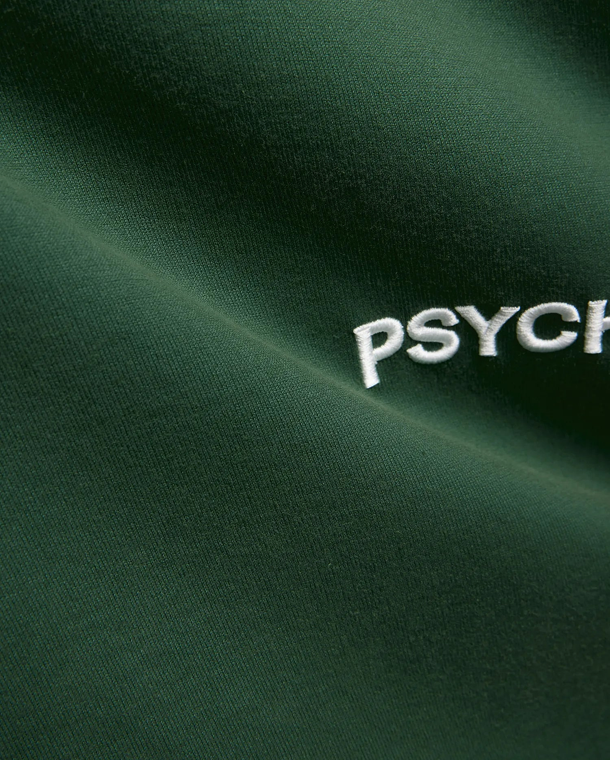 Mens Haiden Relaxed Heavy Weight Tee in dark green, featuring a heavyweight jersey knit texture and a prominent embroidered white Psycho Bunny PSYCH text logo.