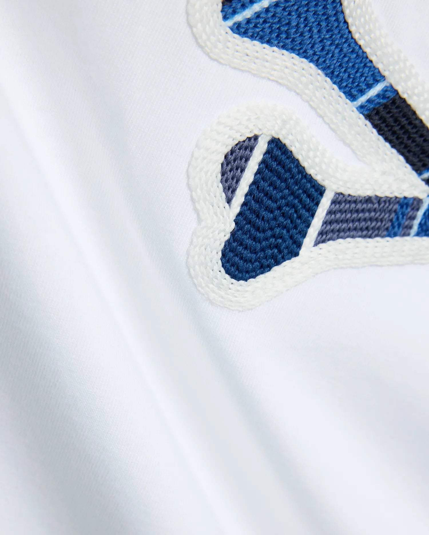 Mens Drew Embroidered Graphic Tee, white jersey knit, featuring a large Psycho Bunny graphic with blue, dark blue, and grey plaid-like embroidery outlined in white.