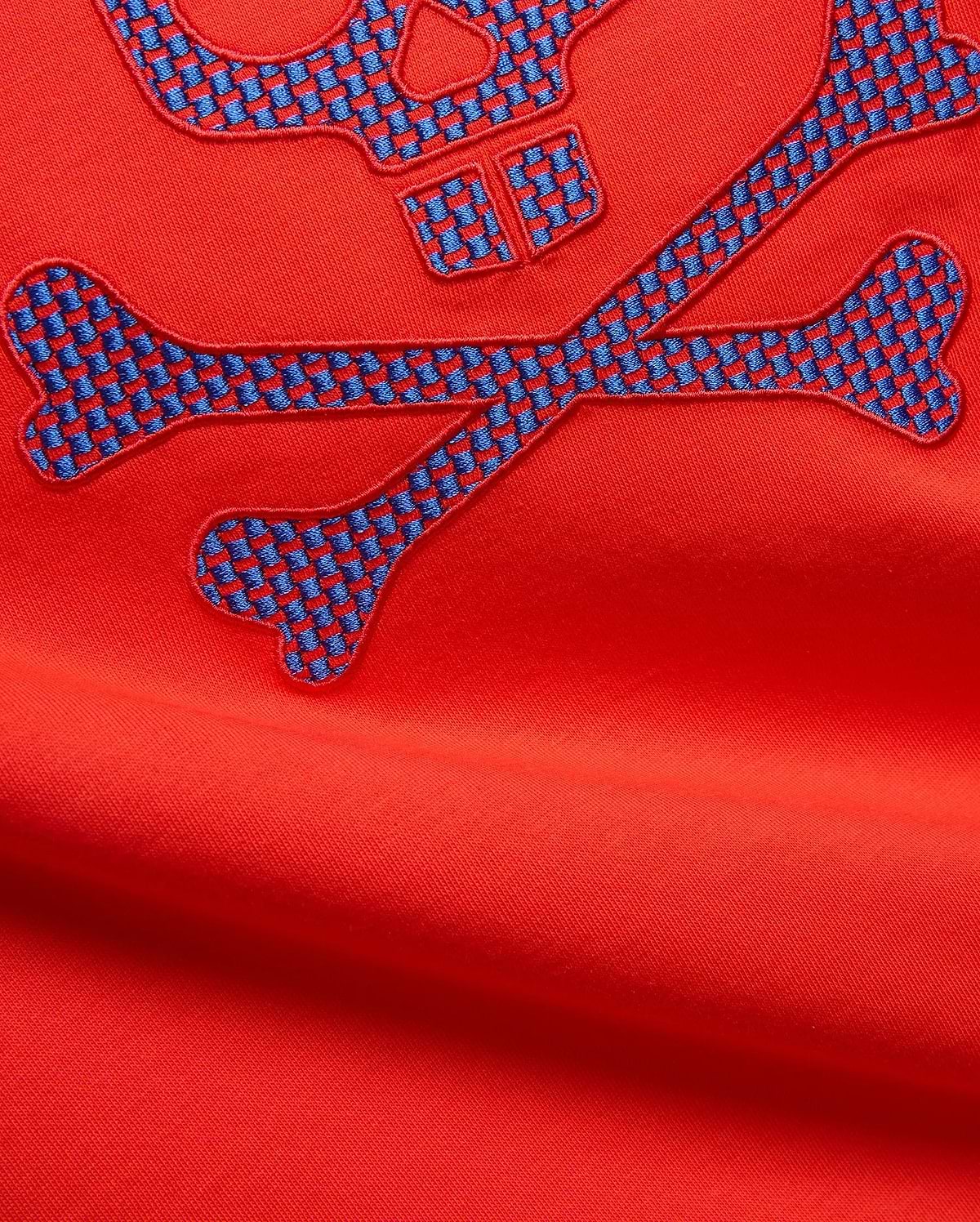 Mens Stan Graphic Tee in vibrant red jersey knit, featuring a large embroidered bunny skull and crossbones logo with a blue and red checkered pattern.