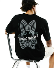 Mens Alex Relaxed Back Graphic Tee in black jersey knit, featuring a large white and grey dotted Psycho Bunny skull graphic on the back and vertical Psycho Bunny text along the shoulders. (1)