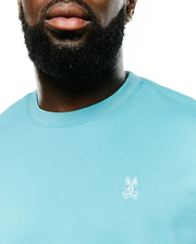 Men's Norman Longsleeve Oversized Tee in aqua blue, featuring a soft jersey knit fabric, ribbed crewneck, and a small white embroidered Psycho Bunny skull logo on the left chest. (2)
