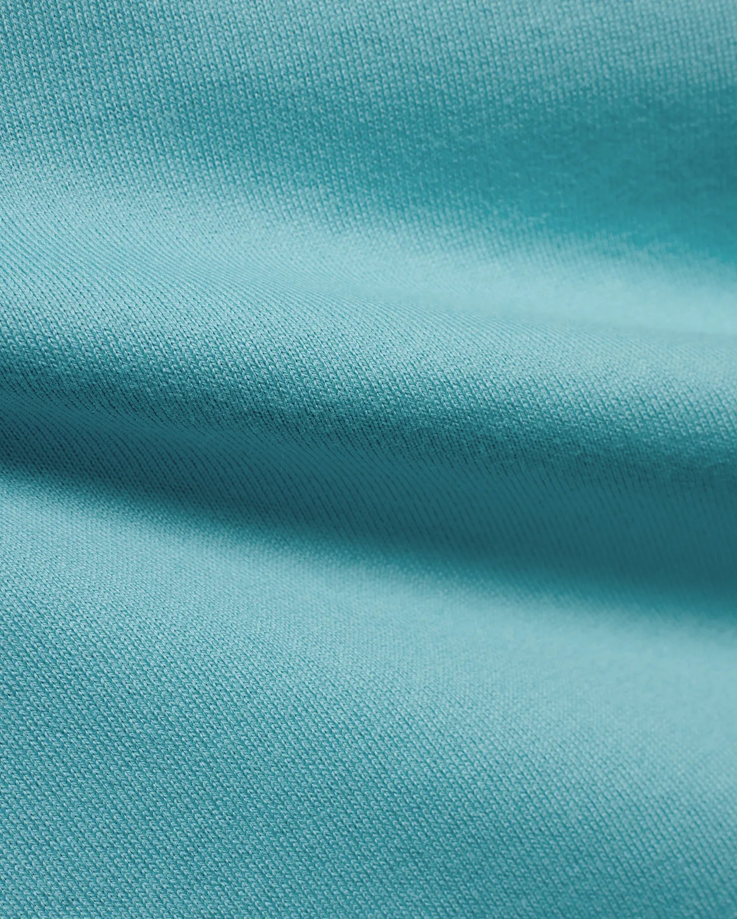 Men's Norman Longsleeve Oversized Tee in a vibrant aqua hue, highlighting the premium, soft jersey knit fabric with a smooth, comfortable texture and subtle draping. (6)