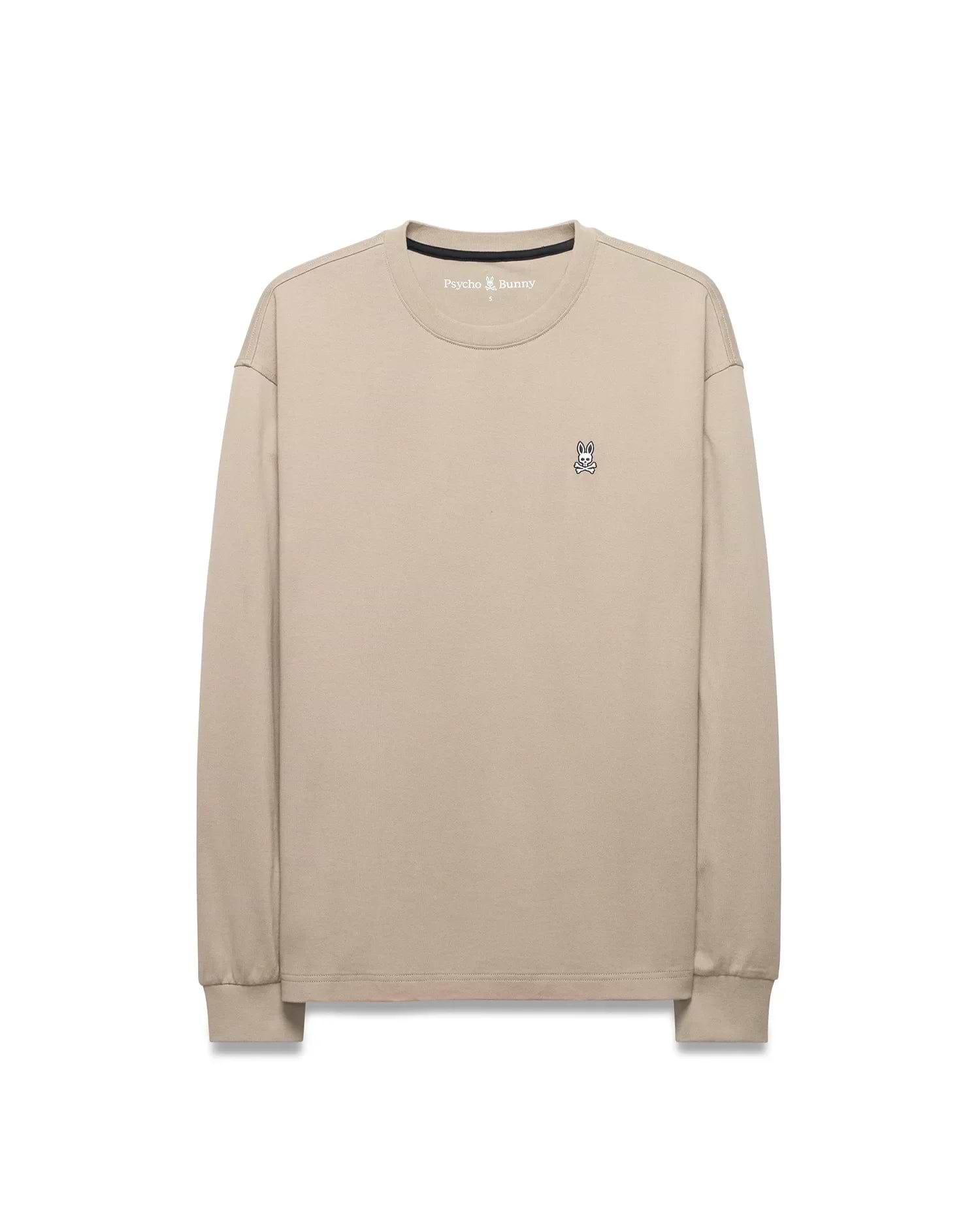 Mens Norman Long Sleeve Relaxed Fit Tee in beige, crafted from soft jersey knit, featuring a small, iconic embroidered Psycho Bunny skull logo on the left chest.