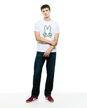 Mens Bruno Graphic Tee, a classic fit white jersey t-shirt featuring a prominent, centered green outline Psycho Bunny skull and crossbones logo graphic on the chest.