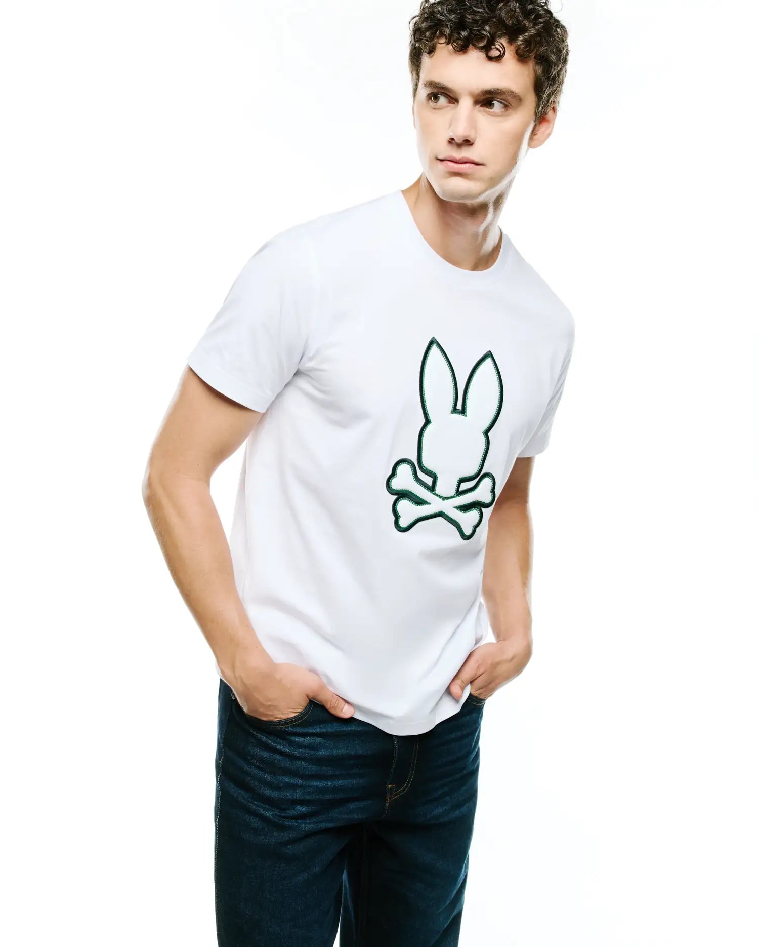 Mens Bruno Graphic Tee, a classic fit white jersey knit t-shirt featuring a prominent central graphic print of the iconic Psycho Bunny skull logo with a vibrant green outline.