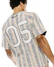 Mens Nathaniel Relaxed Raglan Tee in textured beige and navy vertical stripes, featuring a large white 05 graphic on the back and three small embroidered Psycho Bunny skull logos at the upper back neckline.