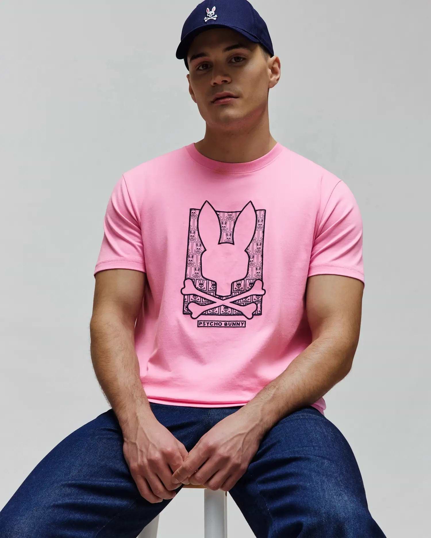 Mens Keon Embroidered Graphic Tee in pink jersey, featuring a large black graphic print of the Psycho Bunny skull logo filled with a repeating bunny pattern, crossed bones, and Psycho Bunny text on the chest. (4)