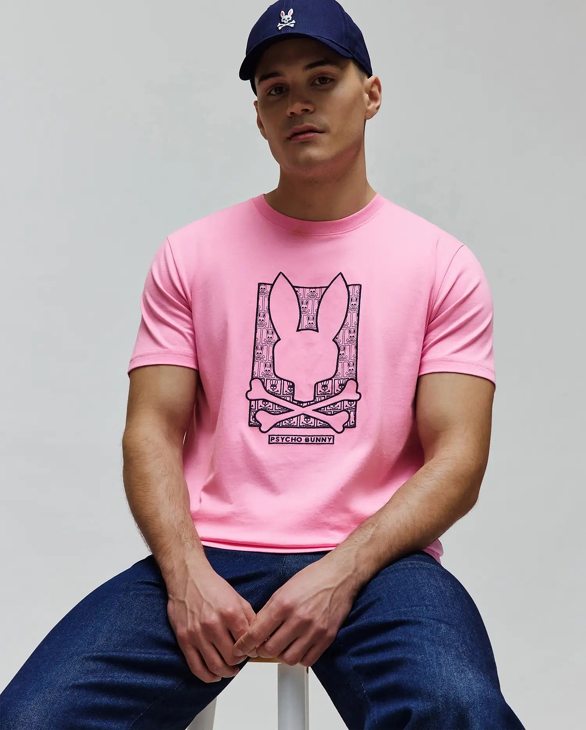 Mens Keon Embroidered Graphic Tee in pink jersey, featuring a large black graphic print of the Psycho Bunny skull logo filled with a repeating bunny pattern, crossed bones, and Psycho Bunny text on the chest. (4)