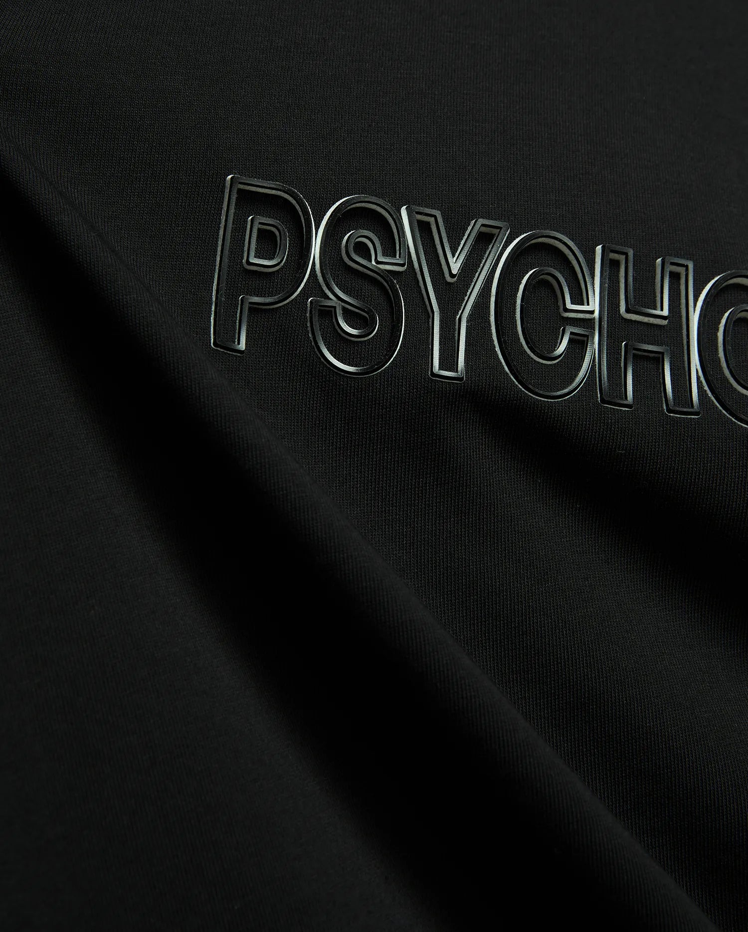 Black Mens Joji Wordmark Graphic Tee crafted from smooth jersey knit, showcasing a prominent, raised, glossy silver-outlined PSYCHO wordmark graphic across the chest.