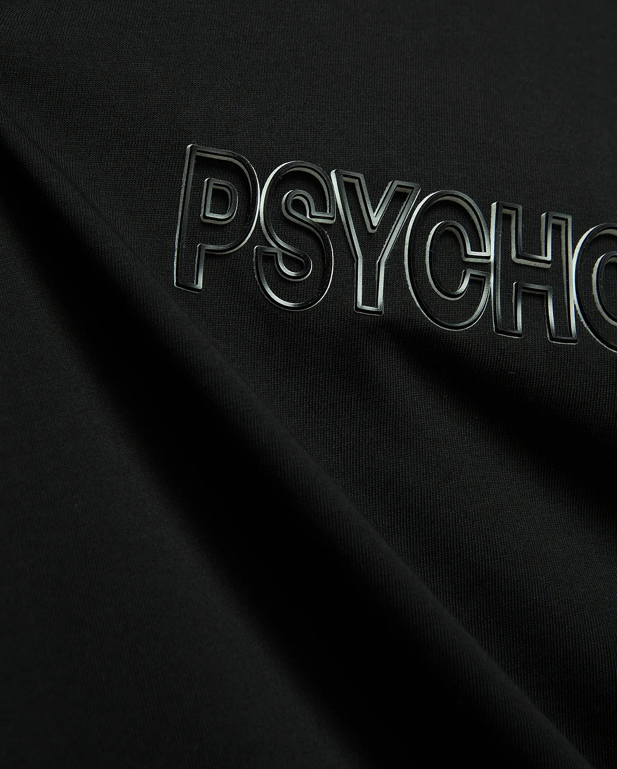 Black Mens Joji Wordmark Graphic Tee crafted from smooth jersey knit, showcasing a prominent, raised, glossy silver-outlined PSYCHO wordmark graphic across the chest.