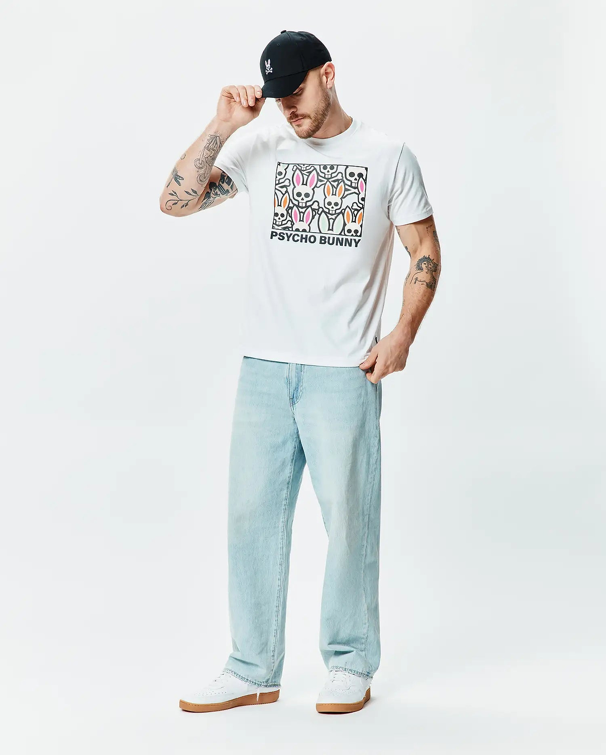 White classic fit jersey T-shirt, Mens Byron Graphic Tee, featuring a large central chest graphic of colorful Psycho Bunny skull logos in pink, green, and orange with black outlines and PSYCHO BUNNY text. (5)