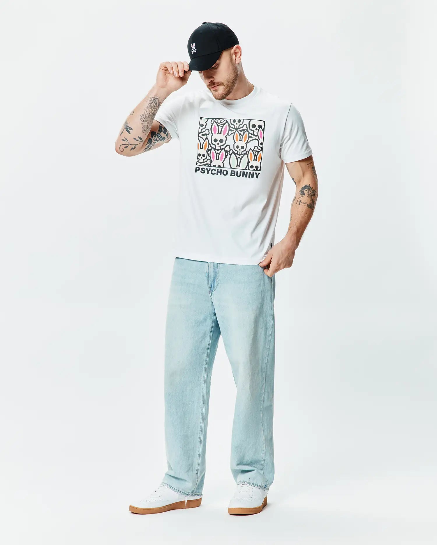 White classic fit jersey T-shirt, Mens Byron Graphic Tee, featuring a large central chest graphic of colorful Psycho Bunny skull logos in pink, green, and orange with black outlines and PSYCHO BUNNY text. (5)