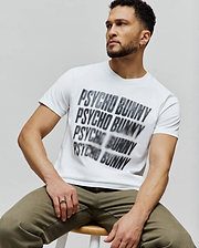 Mens Lawrence Graphic Tee, white classic fit jersey t-shirt featuring a large, central, blurred black and grey repeated Psycho Bunny text graphic. (4)