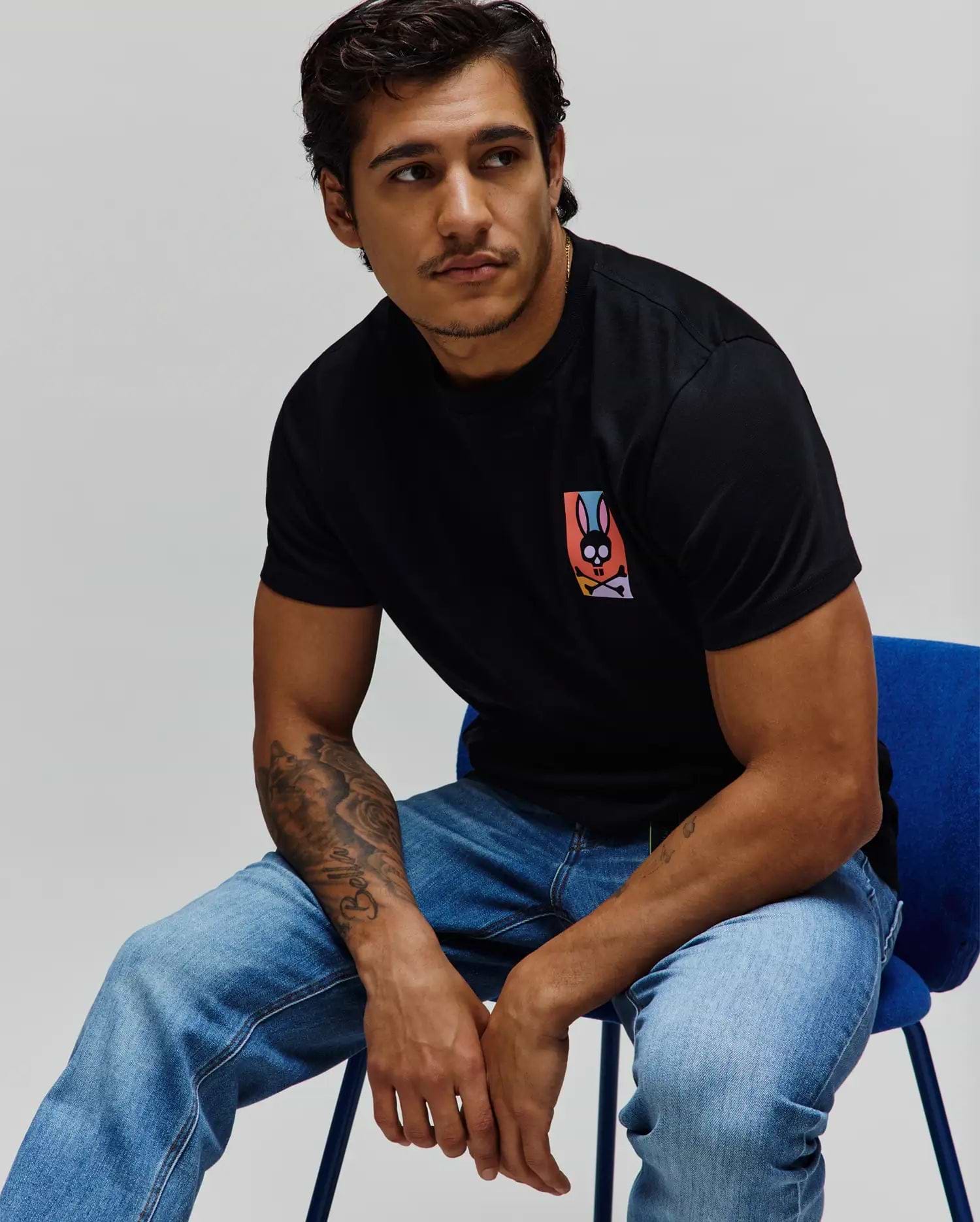 Mens Raphael Back Graphic Tee, a classic fit black jersey t-shirt featuring a small, vibrant multicolor Psycho Bunny skull graphic on the left chest. (4)