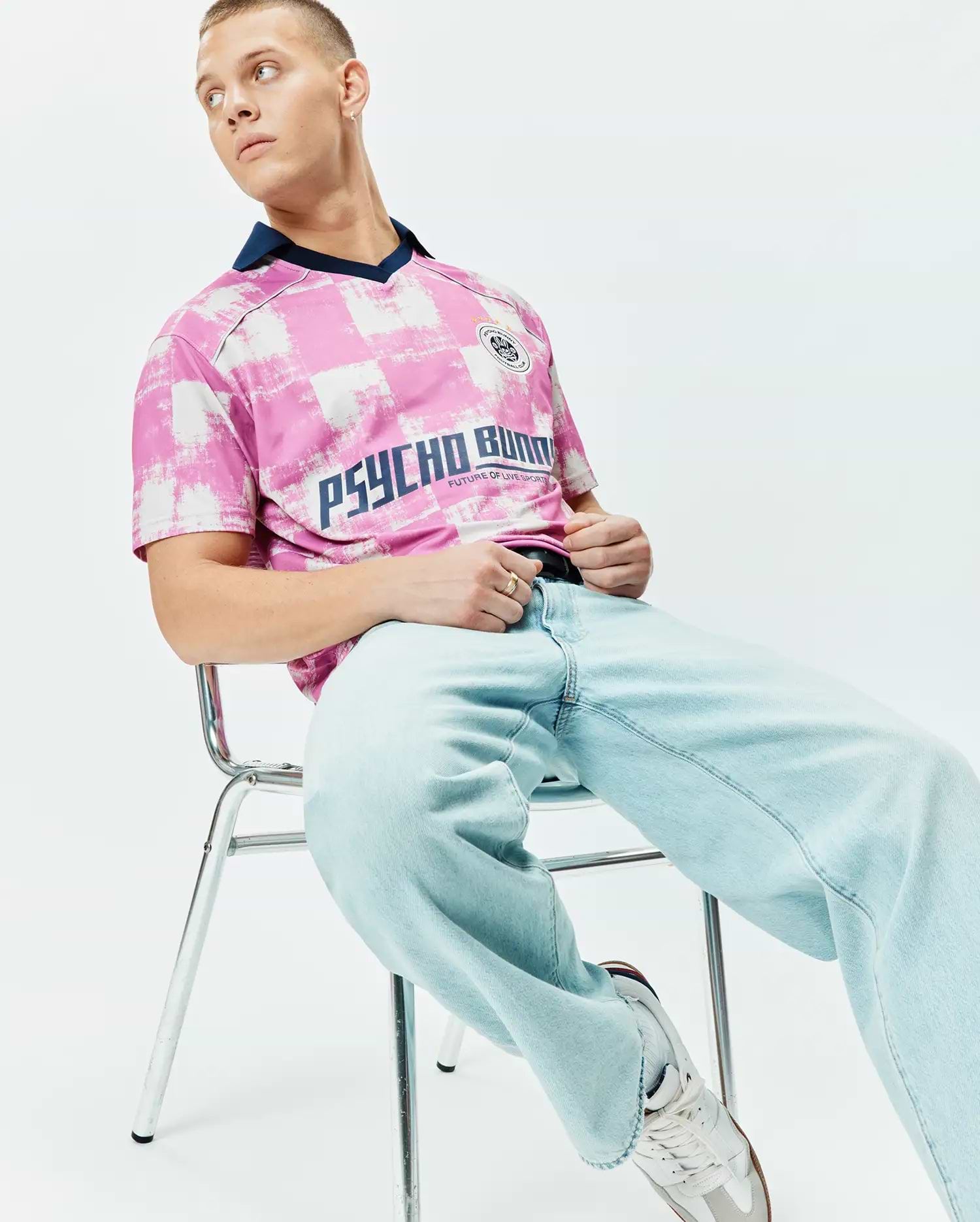 Mens Micah Oversized Soccer Jersey in pink and white distressed checkerboard pattern, featuring a navy V-neck collar, large navy PSYCHO BUNNY text, and a small crest logo on the chest. (3)