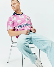 Mens Micah Oversized Soccer Jersey in pink and white distressed checkerboard pattern, featuring a navy V-neck collar, large navy PSYCHO BUNNY text, and a small crest logo on the chest. (3)