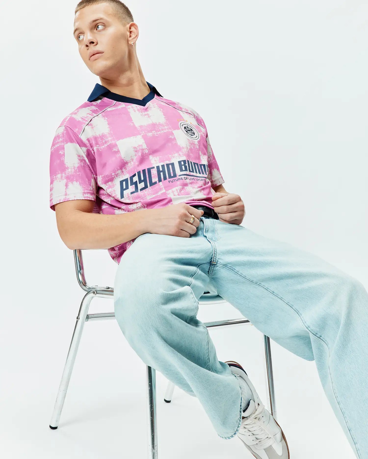 Mens Micah Oversized Soccer Jersey in pink and white distressed checkerboard pattern, featuring a navy V-neck collar, large navy PSYCHO BUNNY text, and a small crest logo on the chest. (3)