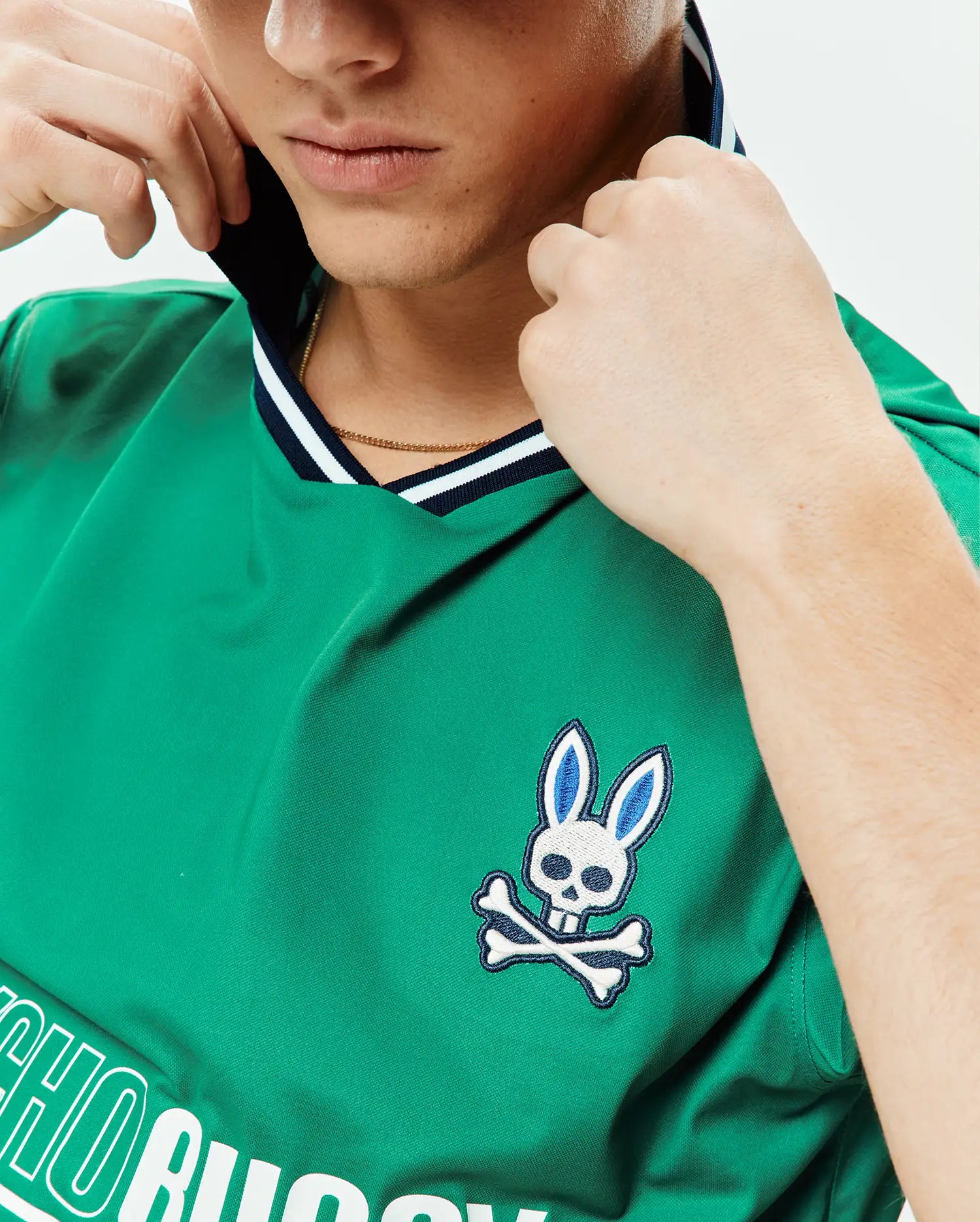Mens Camden Oversized Soccer Jersey in vibrant green, featuring a navy and white striped V-neck, an embroidered Psycho Bunny skull logo on the left chest, and a large white Psycho Bunny text graphic. (3)