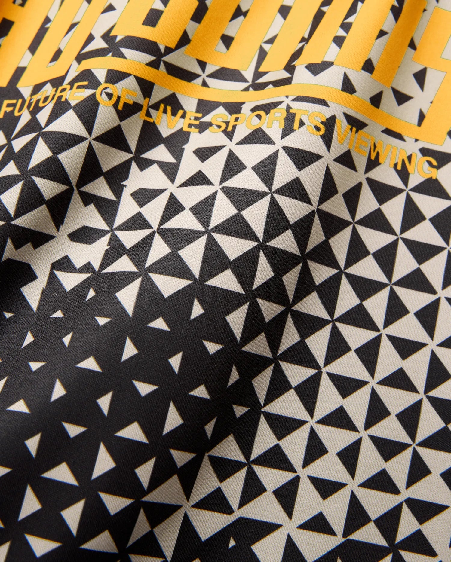 Mens Joshua Soccer Tee with a striking black and cream geometric triangle pattern, featuring a gradient fade and bold yellow FUTURE OF LIVE SPORTS VIEWING text on smooth performance jersey. (6)