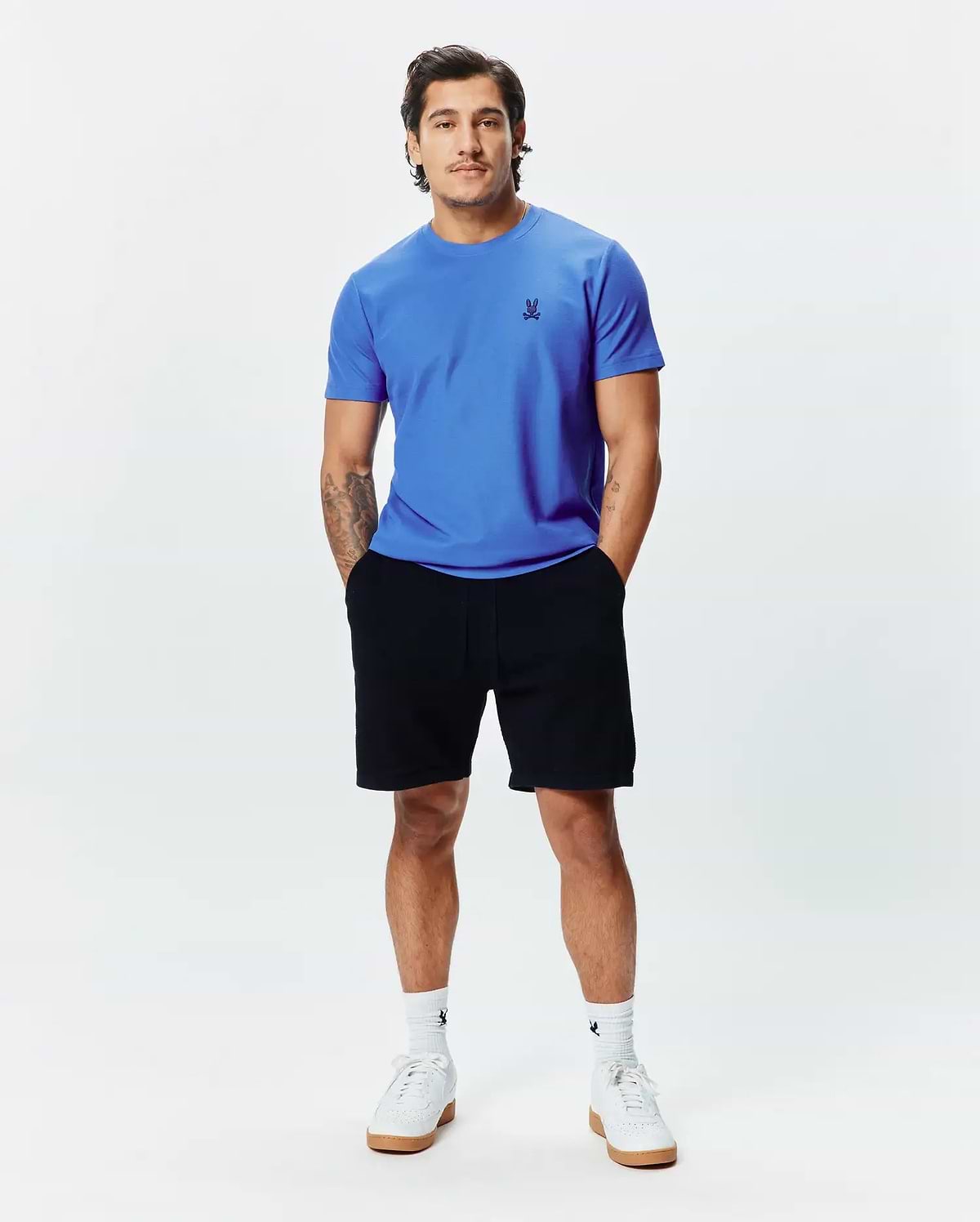 MENS TAYLOR PIQUE TEE in vibrant blue, featuring a classic fit and small black embroidered Psycho Bunny skull logo on the left chest, paired with black jersey shorts.