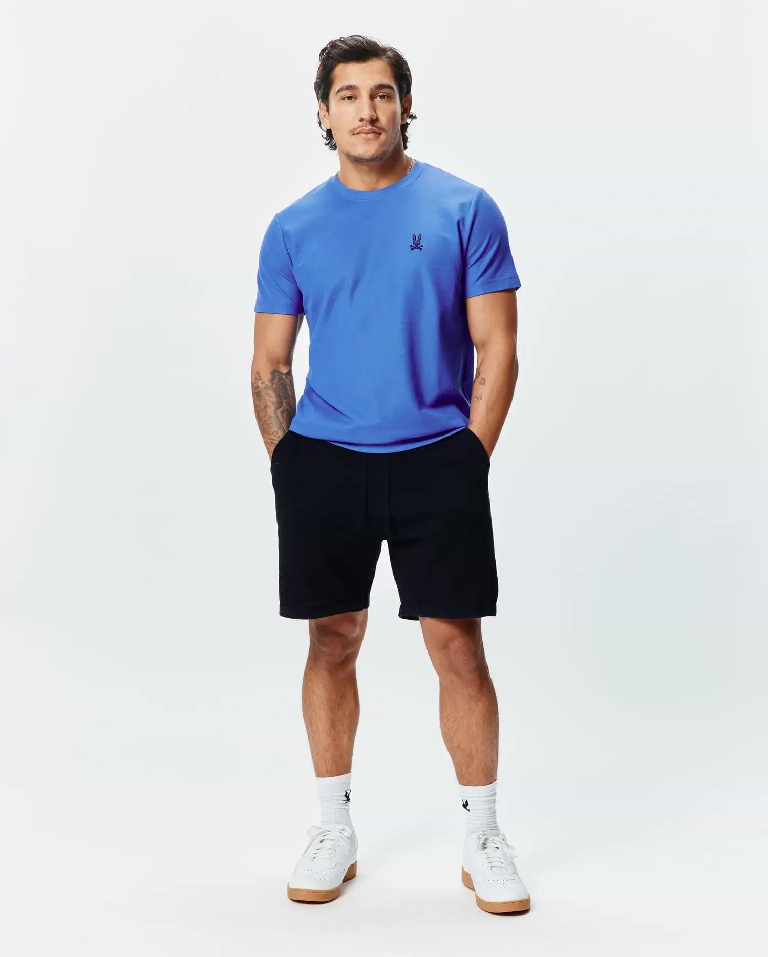 MENS TAYLOR PIQUE TEE in vibrant blue, featuring a classic fit and small black embroidered Psycho Bunny skull logo on the left chest, paired with black jersey shorts.
