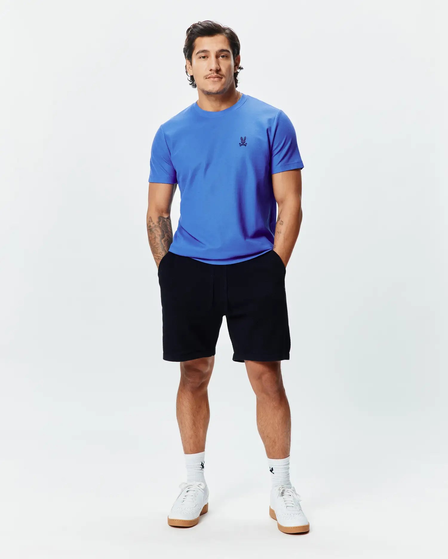 MENS TAYLOR PIQUE TEE in vibrant blue, featuring a classic fit and small black embroidered Psycho Bunny skull logo on the left chest, paired with black jersey shorts.